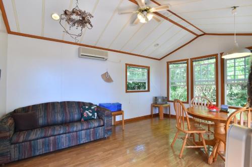 a living room with a couch and a table at PANORAMA Ocean View Cottage in Motobu