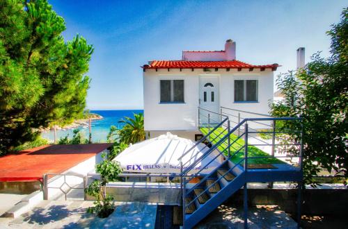 une maison avec un escalier menant à l'océan dans l'établissement Glastres beach apartment, à PalaiónTsiflíkion