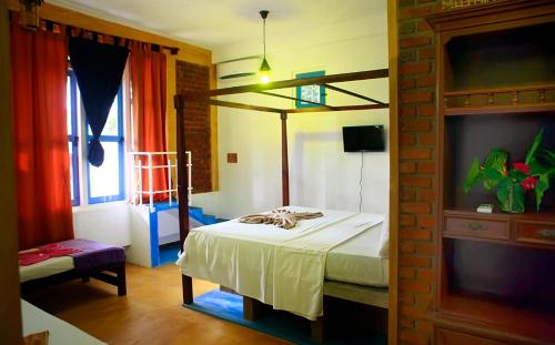 ein Schlafzimmer mit einem Bett in einem Zimmer mit einem Fenster in der Unterkunft The Change Hotel in Kandy