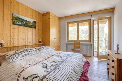 ein Schlafzimmer mit einem großen Bett und Holzwänden in der Unterkunft Casa Viktoria B26 in Arosa