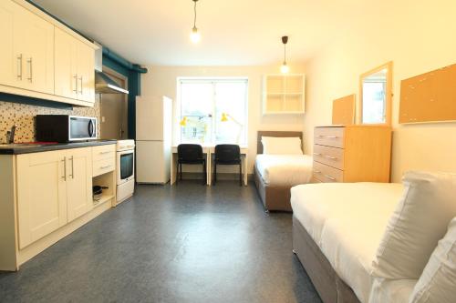 um pequeno quarto com duas camas e uma cozinha e um quarto com uma cama em Tom Dick and Harriet's Accommodation em Dublin