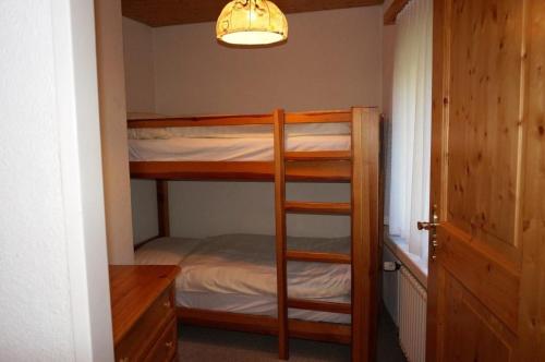 een kamer met 2 stapelbedden en een bureau bij Paradies 026 in Arosa