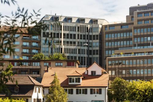 a building in front of tall buildings at EMA House Hotel Suites in Zurich