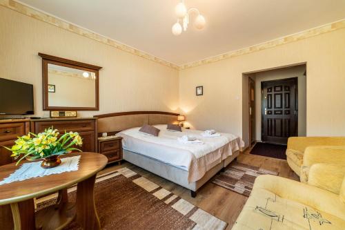 a hotel room with a bed and a table at Dom Wypoczynkowy Leśna Perła in Jastrzębia Góra