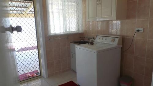 a small kitchen with a washing machine and a window at The Garden House in Tamworth