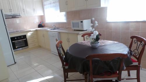 a kitchen with a table and chairs and a microwave at The Garden House in Tamworth