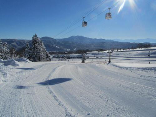 a snow covered ski slope with a ski lift at Villa Monrepos in Myoko