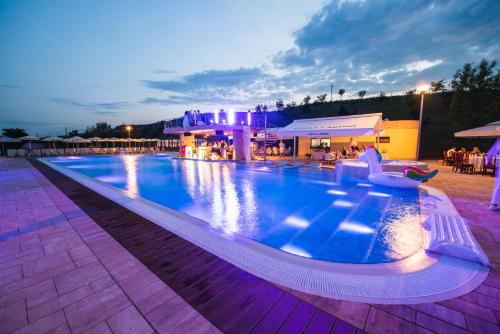 a large swimming pool at a resort at night at Hotel Astoria in Alba Iulia