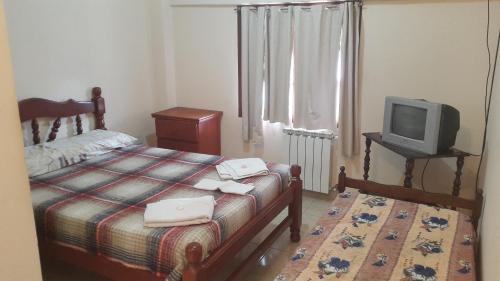 1 dormitorio con 1 cama y TV en una mesa en Alquiler Temporario Salta en Salta