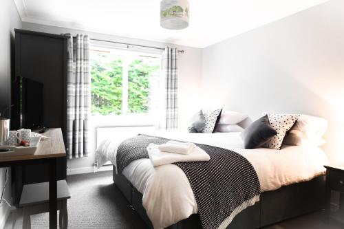 1 dormitorio con cama, escritorio y ventana en The Forge Bed & Breakfast, en Auchterarder