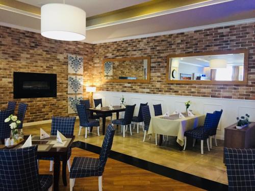 a restaurant with tables and chairs and a brick wall at Hotel Trzy Róże in Lublin