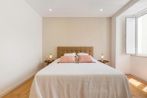 リスボンにあるThe Tile House 95のベッドルーム1室(ピンクの枕が付いた大型ベッド1台付)