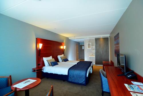 ein Hotelzimmer mit einem Bett und einem Schreibtisch in der Unterkunft Hotel Zuiderduin in Egmond aan Zee