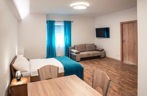 um quarto com uma cama, uma mesa e um sofá em Apartament w Bizancjum 9 PARKING FREE 24H em Klodzko