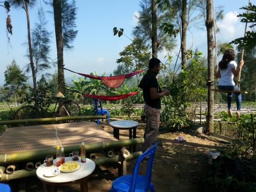 a man standing in a garden with a table and chairs at Harumi Dieng in Wonosobo