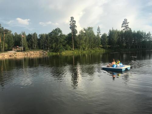 a couple of people in a small boat on a lake at Dzirnavkalns in Cesvaine