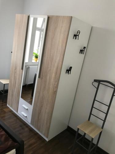 einen Spiegel an der Wand in einem Zimmer mit Stuhl in der Unterkunft F & W Apartment in Erfurt