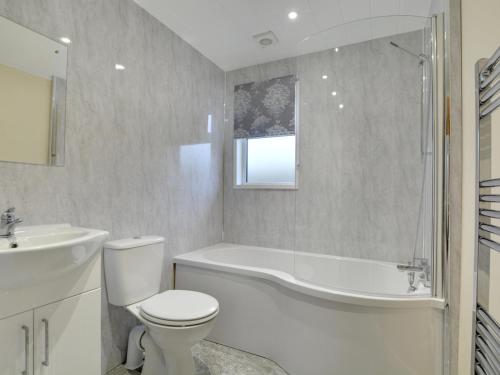a bathroom with a tub and a toilet and a sink at Cackle hill lakes in Biddenden