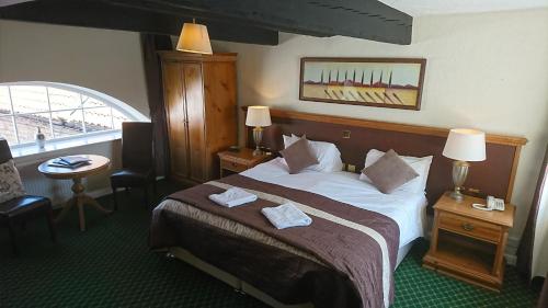 Tempat tidur dalam kamar di George & Dragon Hotel