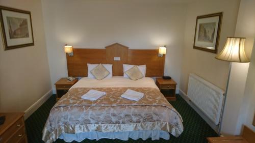 a hotel room with a bed with two pillows at George & Dragon Hotel in Kirkbymoorside