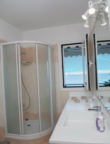 a bathroom with a shower and a sink at Kiveri Luxurious Seaside Apartment in Kiveri
