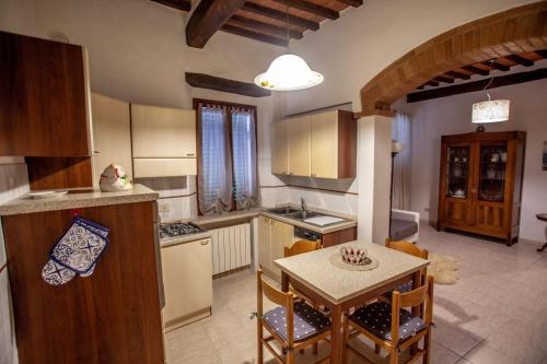 een keuken met een tafel en een eetkamer bij La casa di Francesca in Castelnuovo Berardenga