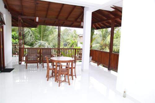 a dining room with a table and chairs on a porch at Submarine Rest in Unawatuna