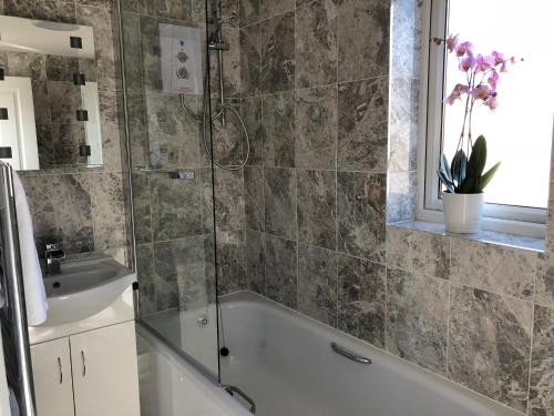 een badkamer met een bad en een wastafel bij Guineas House in Newmarket