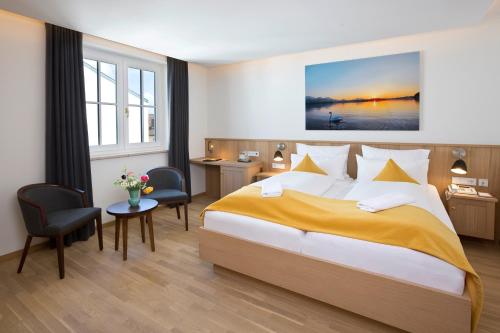 a hotel room with a large bed and a desk at Hotel Hirsch in Füssen