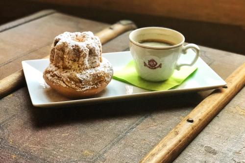 a pastry on a plate next to a cup of coffee at Hôtel de l'Europe by HappyCulture in Strasbourg