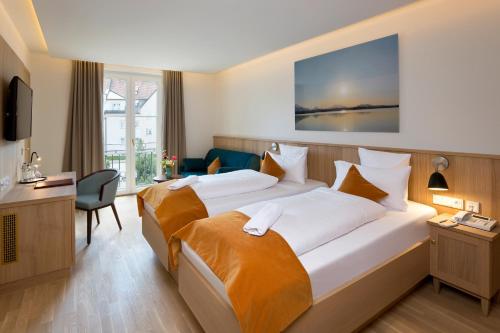 a hotel room with a large bed and a desk at Hotel Hirsch in Füssen