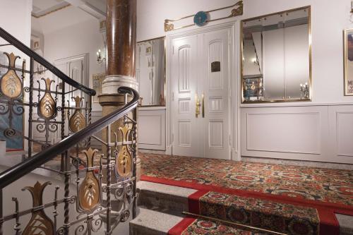 a large room with a large mirror and a stair case at Hotel Paris Prague in Prague