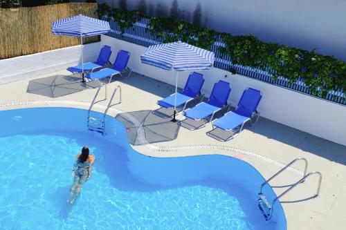 a woman standing in the water in a swimming pool at Kalimera Studios and Apartments in Moraitika