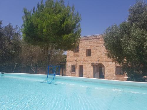 a blue chair sitting in the middle of a swimming pool at Bingemma Paradise Farmhouse in Dwejra