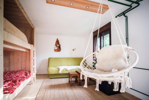 a room with a swinging bed and a couch at Nature nook in Bled