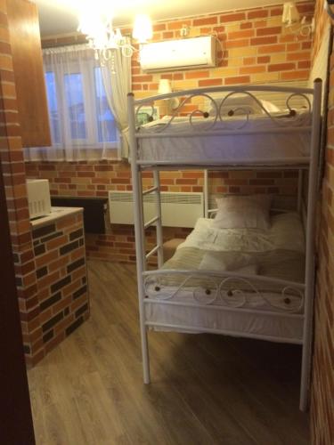 a bunk bed in a room with a brick wall at Zolotoi Bereg 31 in Odesa