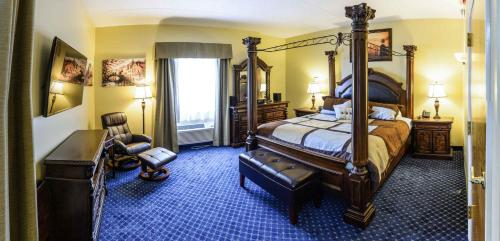 a bedroom with a bed and a chair in it at Asbury Inn & Suites in Wilmore