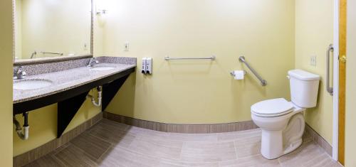 a bathroom with a toilet and a sink and a mirror at Asbury Inn & Suites in Wilmore