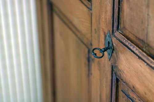 a wooden door with a pair of scissors on it at Le Prieuré in Saint-Dalmas-de-Tende