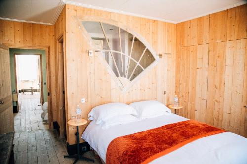 ル・ボワ・プラージュ・アン・レにあるChambre de charme coeur de villageの木製の壁のベッドルーム1室