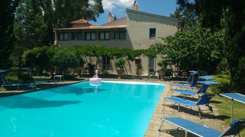 einem Pool mit Stühlen und einem rosa Schwan in einem Haus in der Unterkunft Marrucheto in Giuncarico