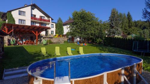 a swimming pool in the backyard of a house at Penzion Garden in Cerny Dul