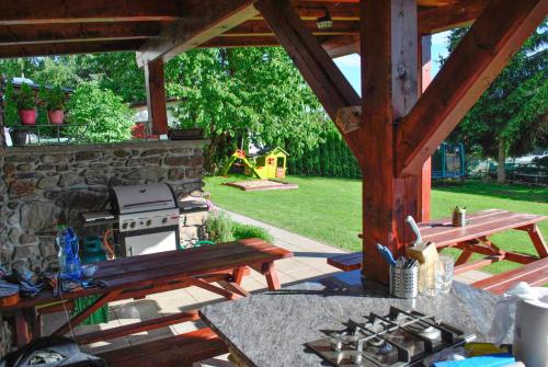 a patio with a picnic table and a stone wall at Penzion Garden in Cerny Dul