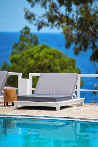 a white lounge chair next to a swimming pool at Akra Morea Hotel & Residences in Monemvasia
