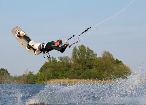 a man on a board in the air over the water at Bungalowpark Het Verscholen Dorp in Harderwijk