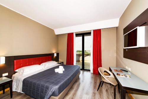 a bedroom with a bed with a red headboard and a desk at Hotel Da Vinci in Milan