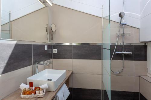 a bathroom with a sink and a shower at Hotel Beau Rivage in Zermatt