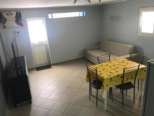 a living room with a yellow table and a couch at Boomerang House - Airport, Center & Beach in Catania