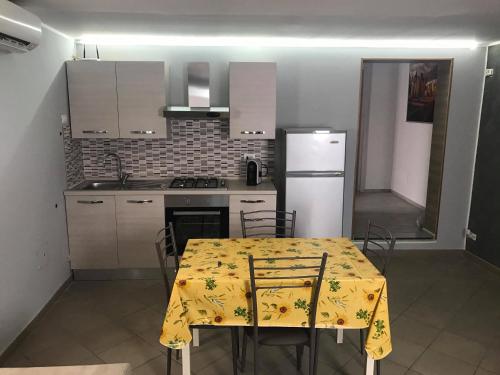 a kitchen with a table with a yellow table cloth on it at Boomerang House - Airport, Center & Beach in Catania