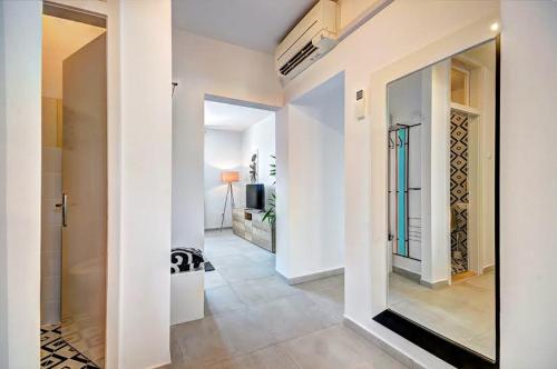 a hallway with white walls and a room with a mirror at Lola app in city center, 4+1 pax in Pula